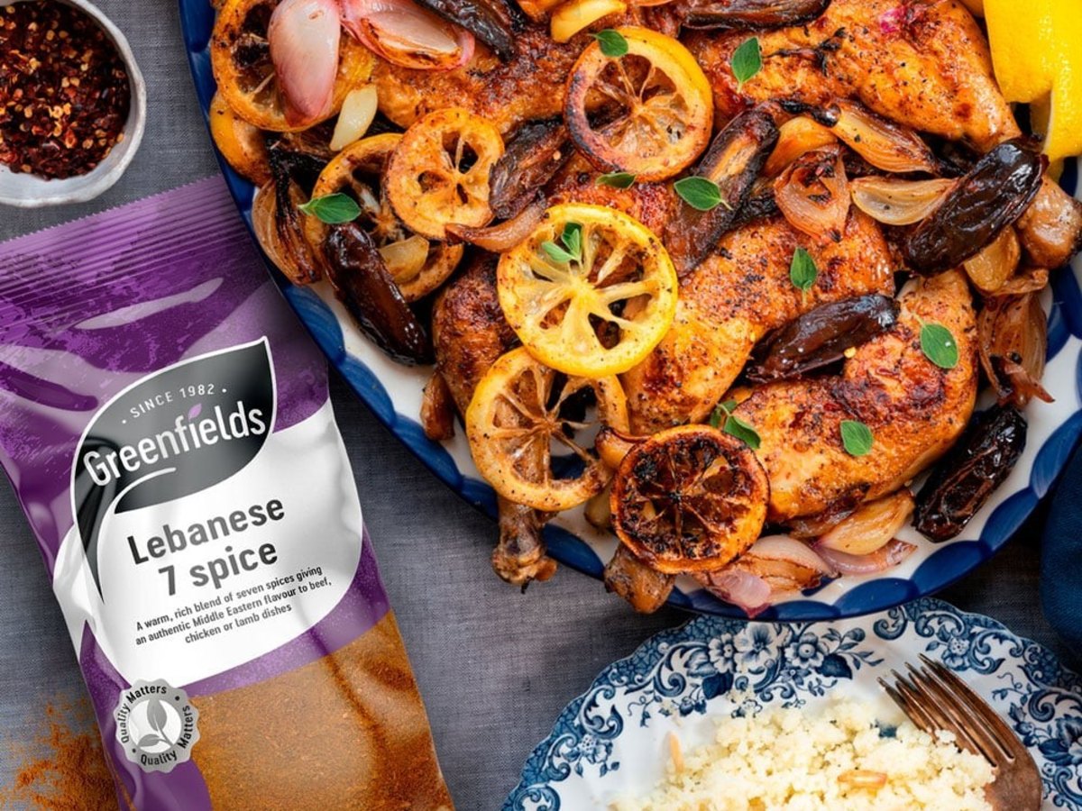 Roast chicken with lemon slices beside a pack of Greenfields Lebanese 7 spice