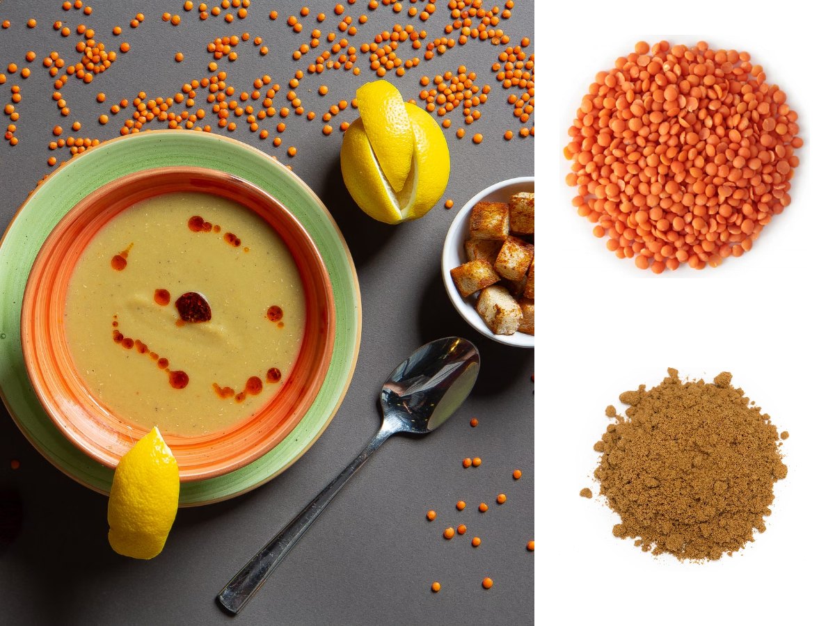 A bowl of smooth red lentil soup with chilli oil, lemon wedges and croutons, with red split lentils and ground cumin