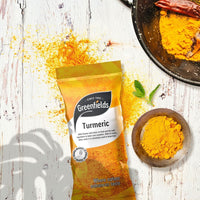 Greenfields turmeric pack beside a bowl of turmeric powder