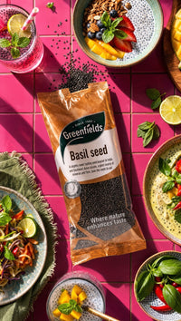 Greenfields basil seed pack surrounded by colourful dishes and drinks