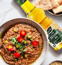 Greenfields pure sesame oil bottle beside a bowl of ful medames and flatbread