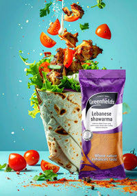 Chicken shawarma wrap with tomatoes beside a Greenfields shawarma spice pack