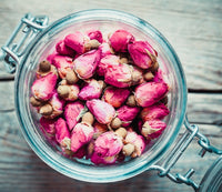 Glass jar filled with dried pink rose buds