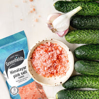 Greenfields coarse Himalayan pink salt pack with a bowl of salt, cucumbers and garlic