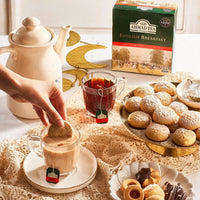 Ahmad Tea English Breakfast served with a teapot, cups and biscuits