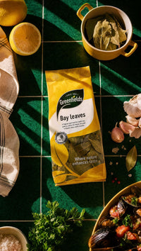 Greenfields bay leaves pack on a green tiled worktop with herbs