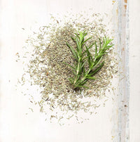 Pile of dried rosemary with a fresh rosemary sprig