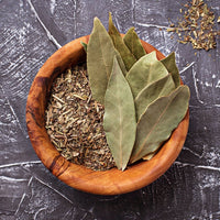Dried bay leaves and herbs in a wooden bowl