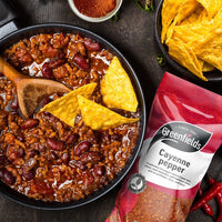 Chilli con carne with tortilla chips beside a Greenfields cayenne pepper pack