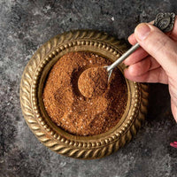 Brass bowl of Lebanese seven spice with a spoon