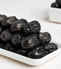 Madina Ajwa dates in a white serving dish
