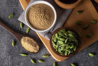 Ground Arabic coffee in bowls with green cardamom pods
